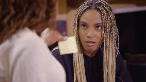 woman placing post-it note on another woman's head - gif